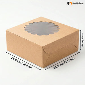 Natural kraft brown square cake box with ornate flower-shaped scalloped petal PVC window on lid, no logo, dimensions 25.5 x 25.5 x 10 cm (10 x 10 x 4 inches), shown in 3/4 isometric angle with bold black measurement arrows on right and bottom edges, visible tuck-lock flap on right side face, unbleached matte natural paper texture finish, on a soft pure white background