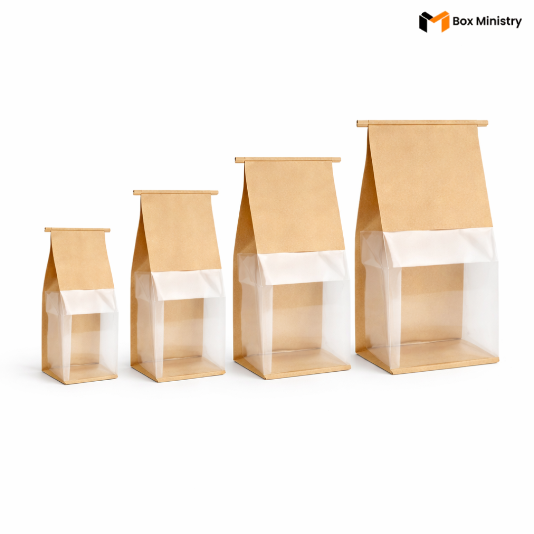 Set of four paper bags with clear window on a white background, branded 'Box Ministry'.