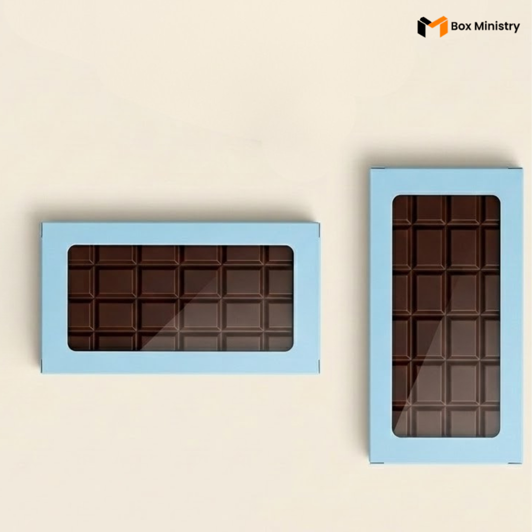 Two chocolate bars in blue boxes with windowed fronts on a beige background, featuring 'Box Ministry' logo.