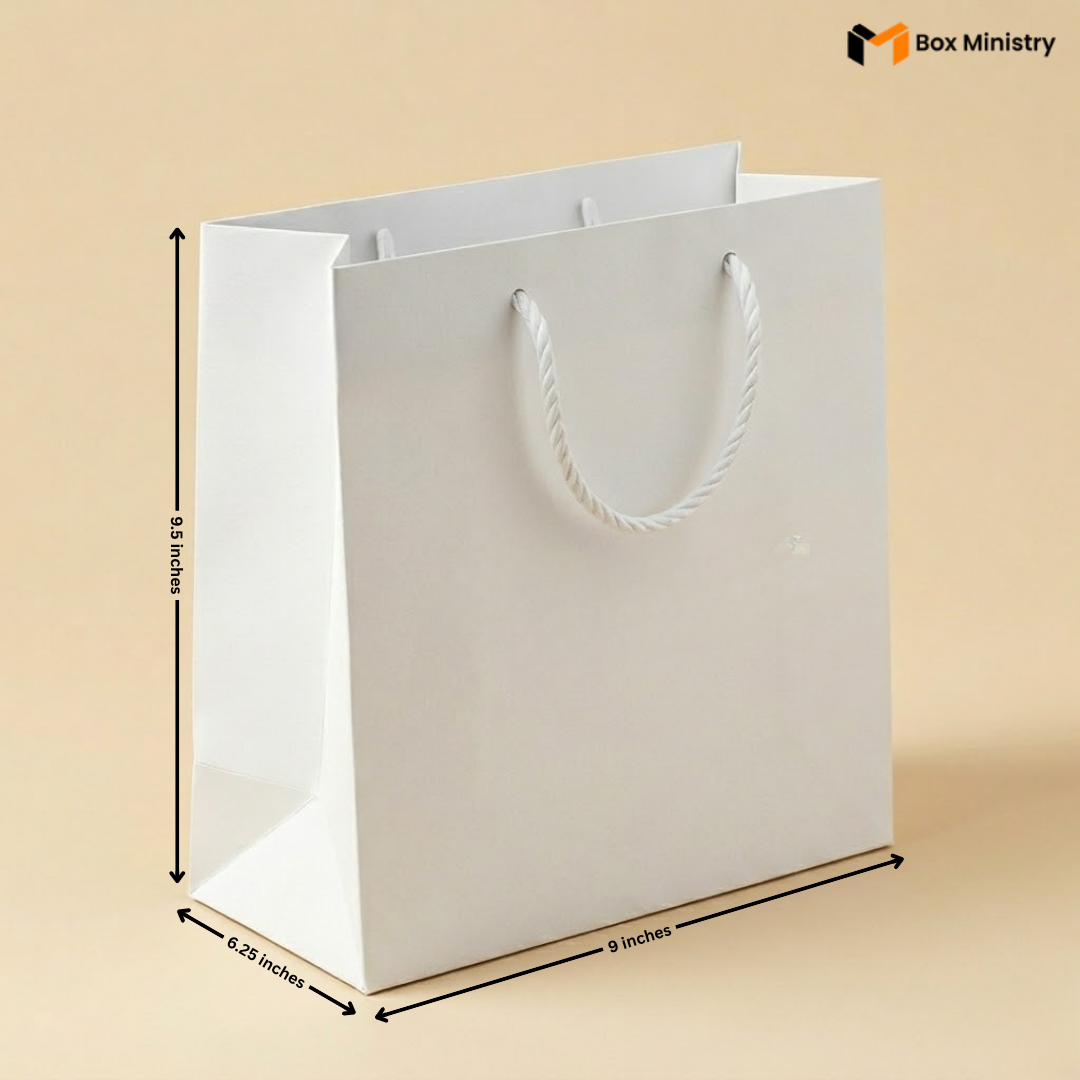 White paper bag with dimensions marked on a beige background, featuring the Box Ministry logo.