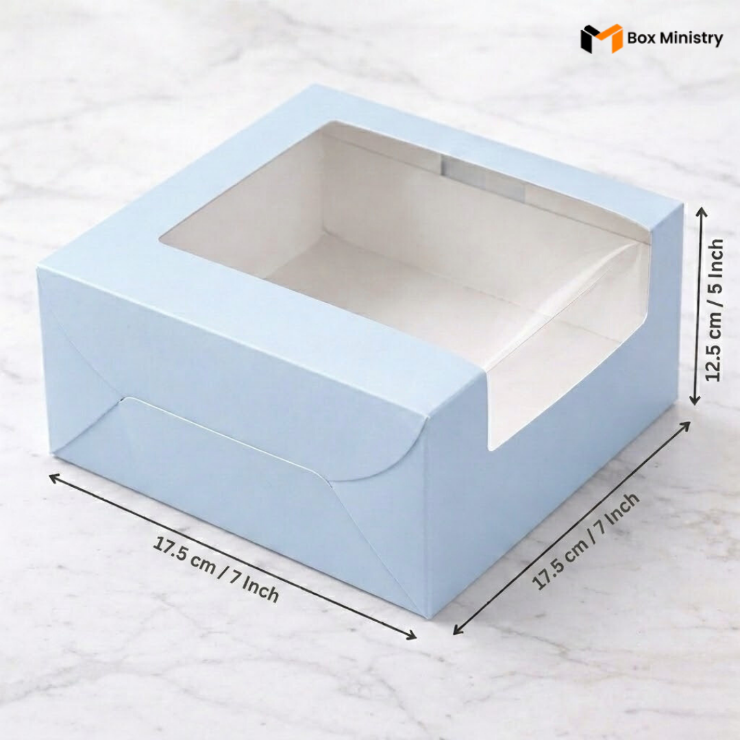 Pastel blue cake box 17.5x17.5x12.5cm with L-shape PVC window on white marble background