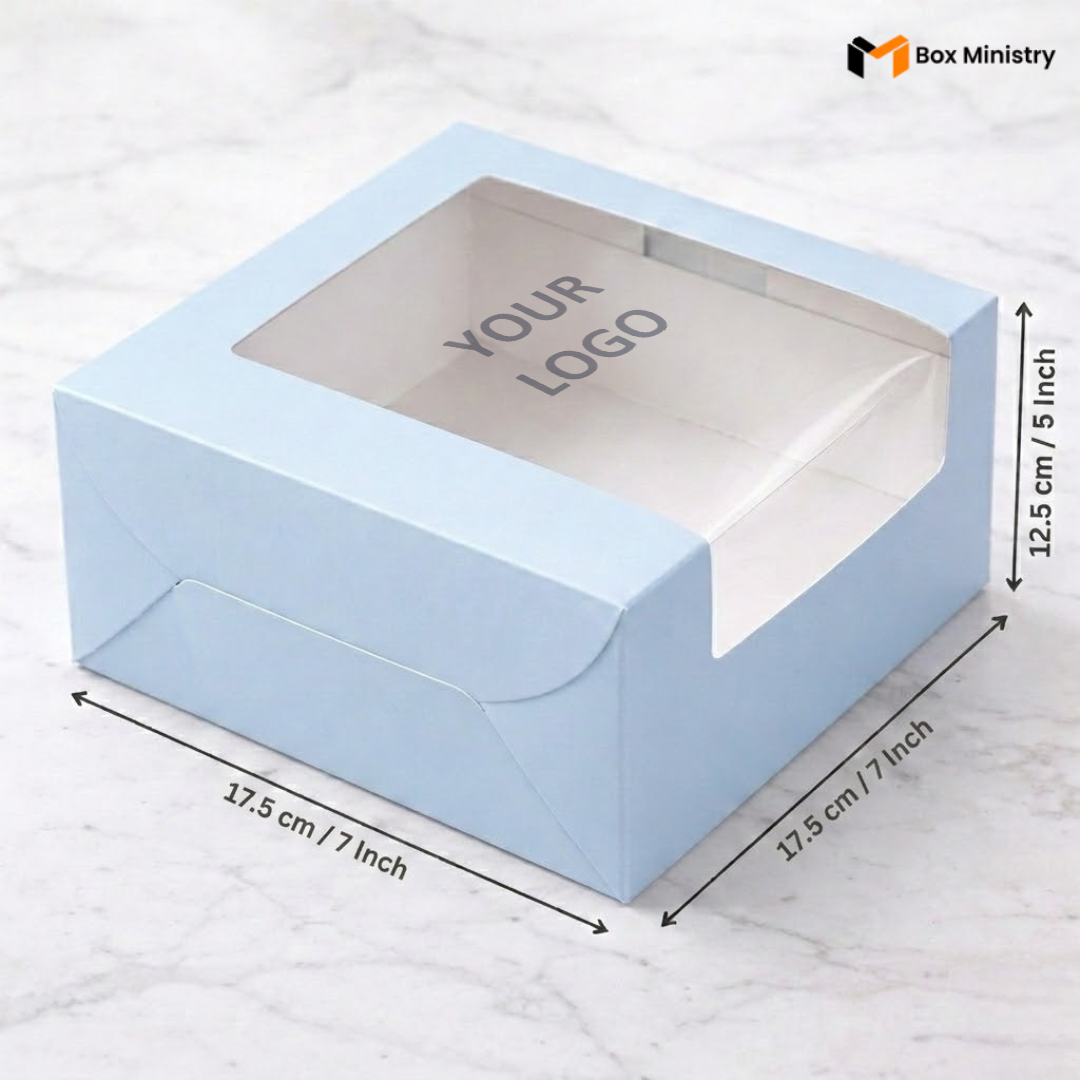 Pastel blue cake box 17.5x17.5x12.5cm with L-shape PVC window on white marble background with custom logo print