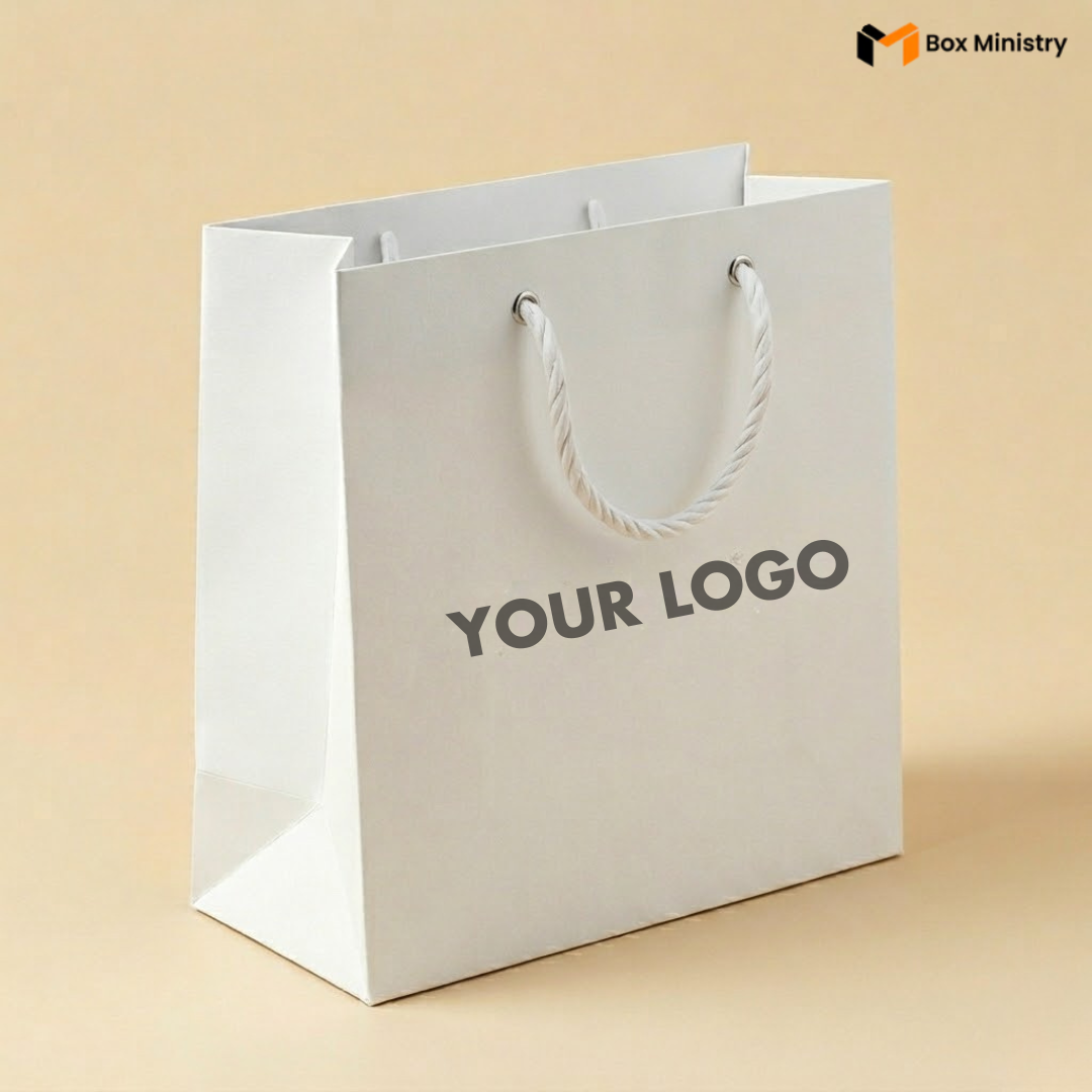 White paper bag with 'YOUR LOGO' text on a beige background, featuring the Box Ministry logo.