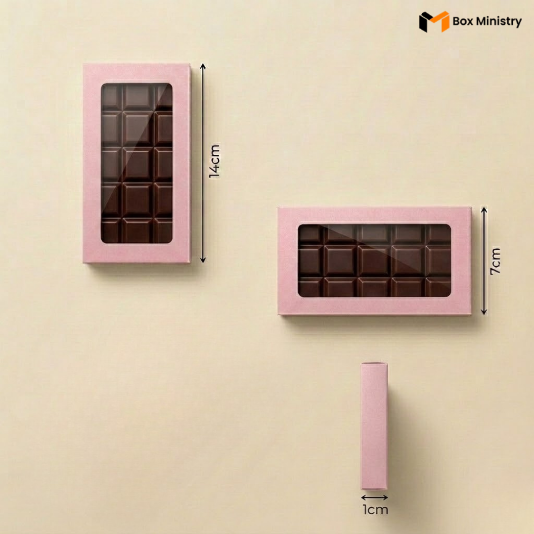 Pink chocolate box with clear window, showing dimensions on a beige background.
