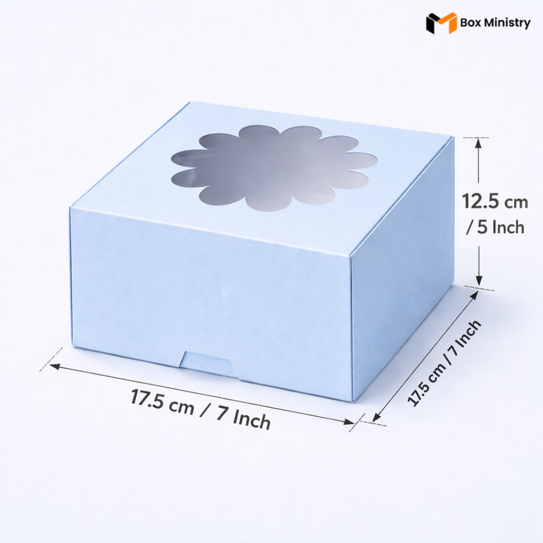 Sky blue flower window cake box 17.5x17.5x12.5 cm (7x7x5 inch) with decorative flower-shaped PVC window on top showing clear interior, taller 5 inch height version clearly visible, dimensions labeled with measurement arrows on pale icy blue background — Blue Flower Window Cake Box .