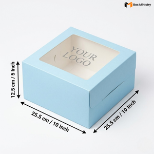 Soft sky blue square cake box with large square clear PVC window on lid showing "YOUR LOGO" text in elegant serif grey font on white interior base, dimensions 25.5 x 25.5 x 12.5 cm (10 x 10 x 5 inches), shown in 3/4 isometric angle with bold black measurement arrows on left and bottom edges, visible tuck-lock flap on right side face, matte finish, on a soft pure white background
