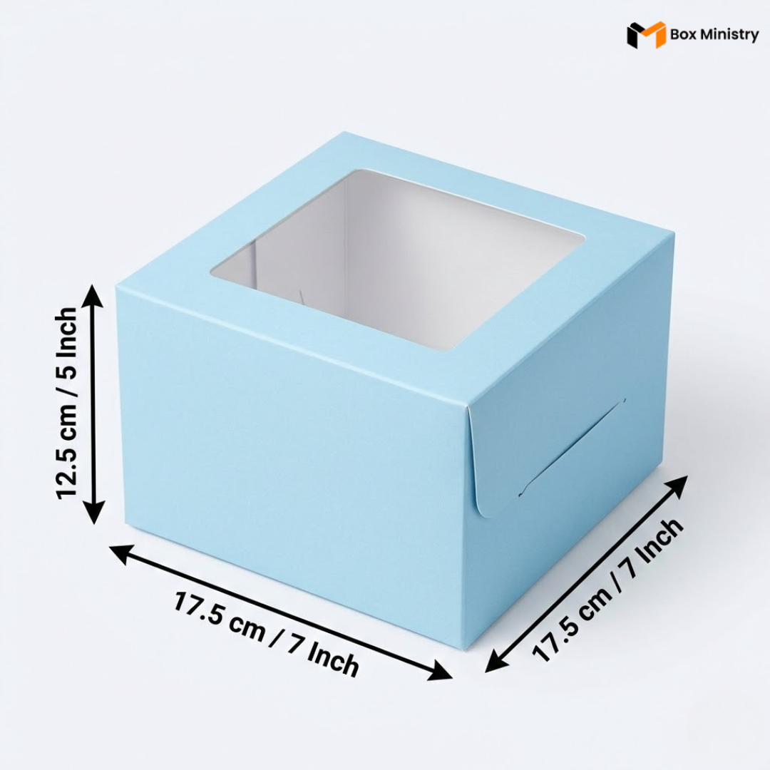 Sky blue square window cake box with clear PVC lid window, dimensions 17.5 x 17.5 x 12.5 cm (7 x 7 x 5 inches), shown in 3/4 isometric angle with measurement arrows, white interior lining visible through window, on a soft light grey-white background