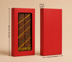 Red chocolate box with a window displaying chocolate bars, measurements indicated on a beige background