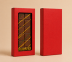Red chocolate box with a window displaying a chocolate bar on a beige background