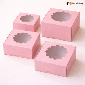 Four pink flower window cake boxes arranged in a 2x2 grid on a soft white background — each box features a decorative circular flower-shaped PVC window on the lid with scallop petal edges — Pink Flower Window Cake Boxes