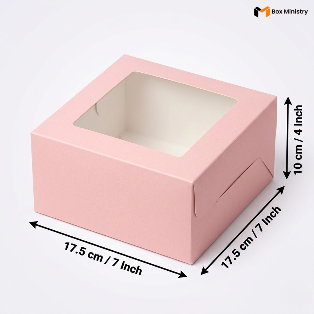 Soft blush pink square window cake box with clear PVC lid window revealing clean white interior, dimensions 17.5 x 17.5 x 10 cm (7 x 7 x 4 inches), shown in 3/4 isometric angle with bold black measurement arrows on right and bottom edges, visible tuck-lock flap on right side face, matte finish, on a soft light grey-white gradient background
