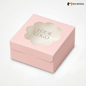 
Soft blush pink square cake box with large square clear PVC window on lid showing "YOUR LOGO" text in elegant serif dark charcoal font centered on white interior base, positioned at 3/4 isometric angle, visible tuck-lock flap on right side face, tall upright shape with prominently visible side walls, matte finish, on a soft pale pink to warm white gradient background

