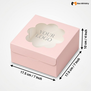 Soft blush pink square cake box with ornate flower-shaped scalloped petal PVC window showing "YOUR LOGO" text in elegant serif grey font on white interior base, dimensions 17.5 x 17.5 x 10 cm (7 x 7 x 4 inches), shown in 3/4 isometric angle with bold black measurement arrows on right and bottom edges, visible side lock closure on front face, flat matte pink finish, on a soft pure white background

