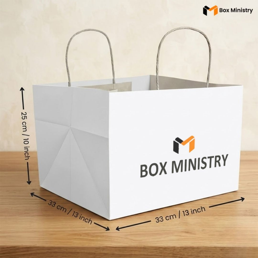 White paper bag with 'Box Ministry' logo and dimensions on a wooden surface