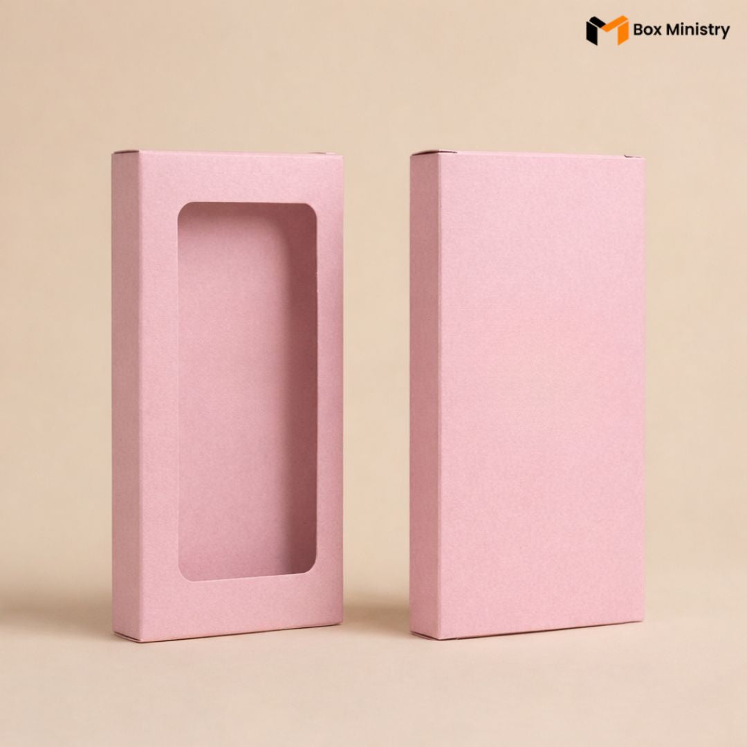 Two pink packaging boxes with a clear window on a beige background, featuring the Box Ministry logo.