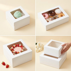 Four-panel image showing white square window cake boxes in different use cases — top left: small box with mint green frosted cupcake visible through square window, top right: rectangular box with 5 assorted donuts visible through wide window, bottom left: tall square box with blush pink strawberry and daisy decorated celebration cake visible through window with loose strawberries beside, bottom right: two stacked white boxes with a hand placing smaller box on top beside white roses — White Square Window 