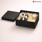 Black gift box with a candle and wrapped gift on a light background, featuring 'Box Ministry' logo.